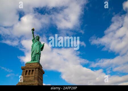 Statue of Liberty isolated on the blue sky with the white clouds in New York state , USA . December 25, 2018. View from the bottom  Stock Photo