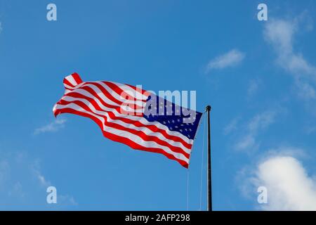 Flag of the United States isolated on the blue sky with the white clouds in New York , USA . December 25, 2018 Stock Photo