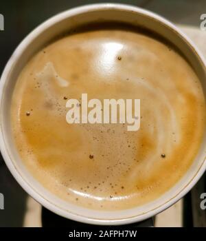 Cappuccino coffee in mug close up. Full cup of latte, mocha with milk froth . macro detail of hot caffeine drink. View from top Stock Photo