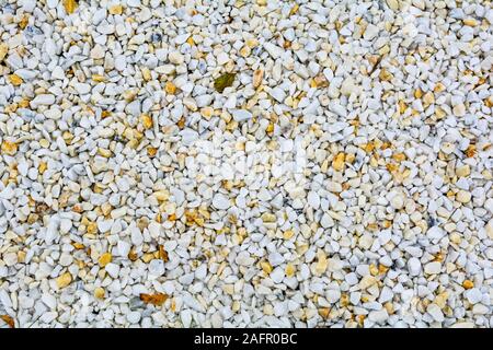 Small White and yellow pebble background. Top view of white and yellow gravel stone texture Stock Photo