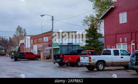 MAY 21,  2019, BIG SANDY, MONTANA,  USA - Storefronts of Big Sandy, Montana with parked pickup trucks Stock Photo