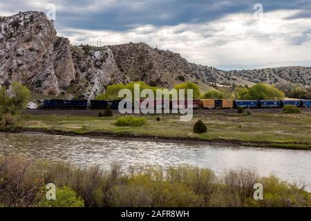 MAY 23 2019, USA - THREE FORKS, MT - Missouri River Breaks National Monument, the source of the Missouri River, freight train runs along river Stock Photo