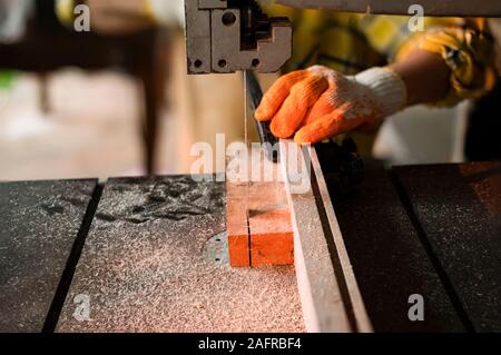 Woman sawed wood at the table in the workshop Stock Photo