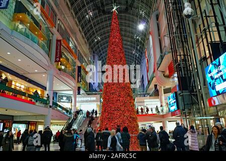 TORONTO - DECEMBER 2019:  The Eaton Center shopping mall is brigtly decorated for Christmas as busy shoppers walk on different levels. Stock Photo