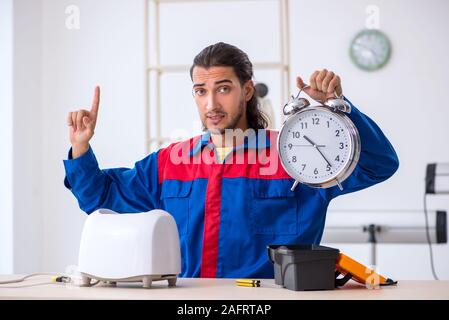 The young male contractor repairing toaster at workshop Stock Photo