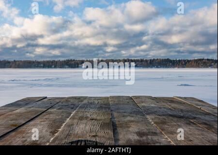 Countertop overlooking the winter lake. Winter gazebo on the shore of a frozen lake. Stock Photo