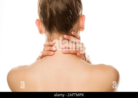 Young tired woman touches her neck on white background Stock Photo