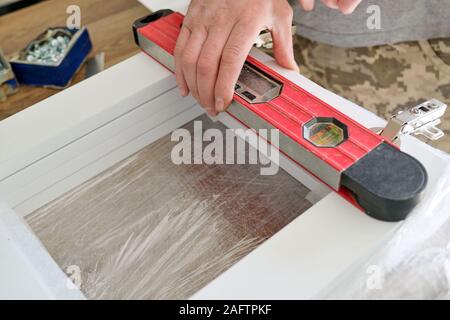 Furniture assembly. Carpenter using building level Stock Photo