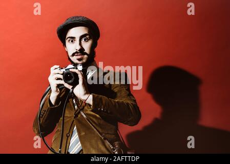 very positive photographer posing in studio with camera Stock Photo