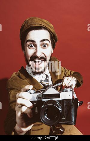 very positive photographer posing in studio with camera Stock Photo