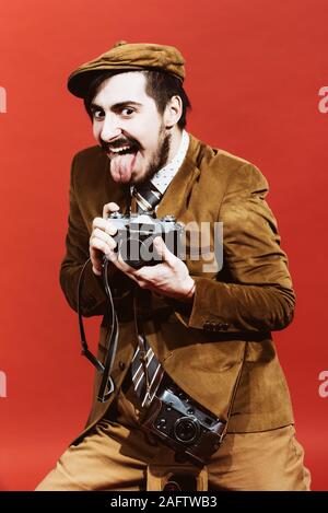 very positive photographer posing in studio with camera Stock Photo