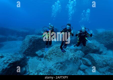 Children discover scuba diving at a rocky reef, Zakynthos island, Greece Stock Photo
