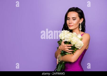 Close-up portrait of nice attractive lovable glamorous charming chic dreamy wavy-haired lady holding in hands smelling fresh natural roses isolated Stock Photo