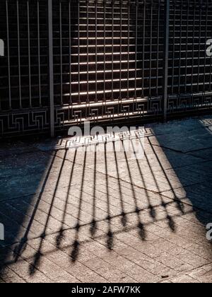 view of the shadow of a metallic railing gate drawn on the floor Stock Photo