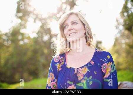 Portrait smiling, serene woman in sunny park Stock Photo
