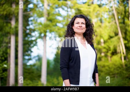 Portrait confident, serene woman in woods Stock Photo