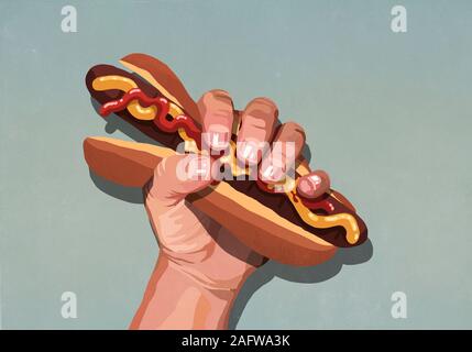 Mans hand squeezing hot dog Stock Photo