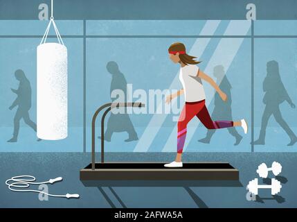 Business people walking behind woman running on treadmill Stock Photo