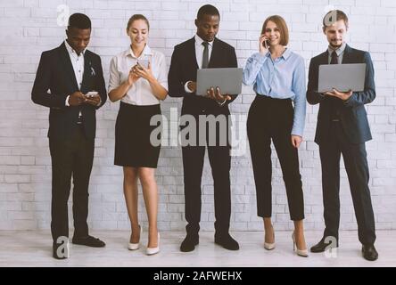 Diverse team with tablet pc, computers and smartphones Stock Photo