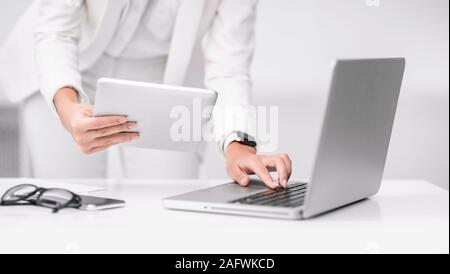 Cropped image of busy girl using tablet and computer Stock Photo
