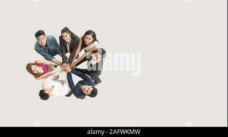 Top view of business people standing with their hands together in a huddle stack hand teamwork assemble together. Stock Photo