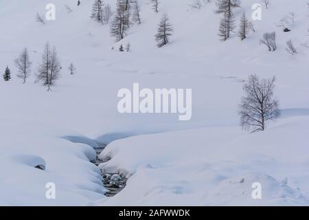 Close shot of a stream covered in snow. Kaunertal valley in Tyrol, in the Austrian Alps. Massive snow falls are covering this area in winter. Stock Photo