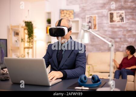 Elderly man experiencing new virtual reality technology for the first time in his home Stock Photo