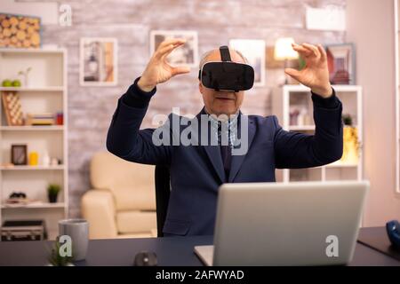 Elderly man experiencing new virtual reality technology for the first time in his home Stock Photo