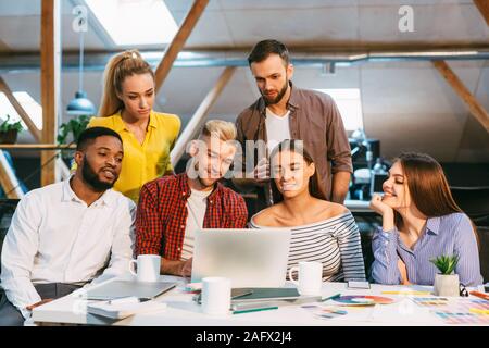 Happy creative team using laptop at meeting in office Stock Photo
