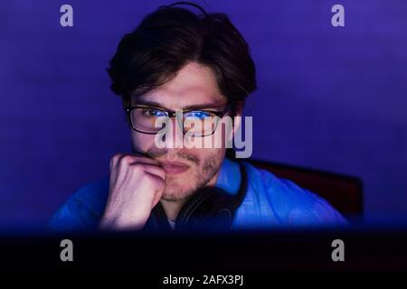 Serious concentrated developer working on computer at night Stock Photo