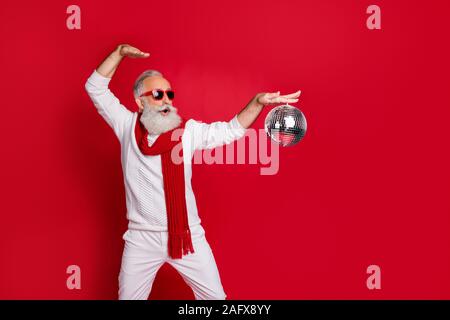 Portrait of his he nice cool handsome cheerful cheery glad positive carefree gray-haired man in pullover sweater having fun spinning glossy ball Stock Photo