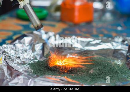 chemical reaction of ammonium dichromate if to set fire to it on the foil Stock Photo