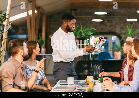 Young team choosing colors for new project, discussing work Stock Photo