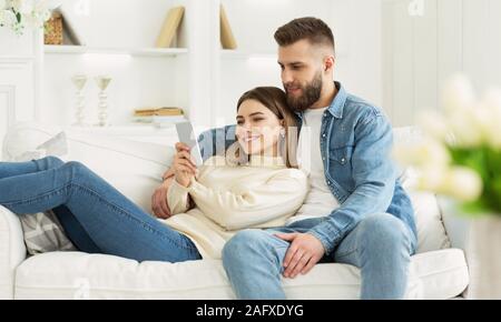 Happy couple in love using smartphone together Stock Photo