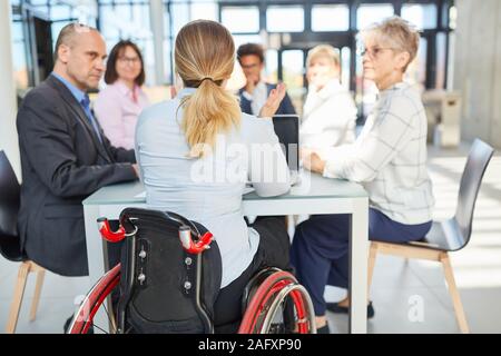 Business woman in a wheelchair in a project meeting together with colleagues Stock Photo