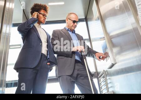 Visually impaired or blind man in the elevator presses button for inclusion concept Stock Photo