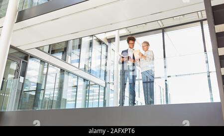 Business people at a meeting on the gallery with tablet computer Stock Photo