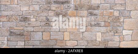 Panorama of a bright, old, partly weathered stone wall Stock Photo