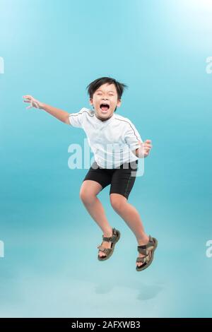 Happy boy is jumping at studio. Stock Photo