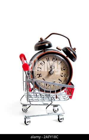 Retro alarm clock in shopping cart on white background. Stock Photo