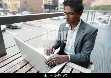 Young handsome man is sitting at the table Stock Photo