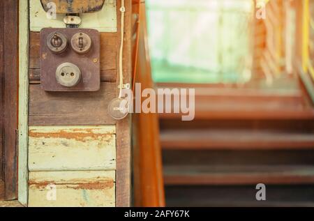 Close up to a very old light electric retro switch on on a wooden board. Vintage switch, Selective focus Stock Photo