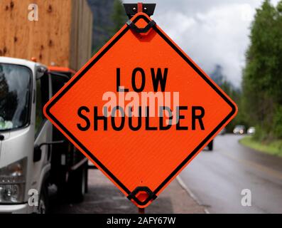 Low Shoulder Warning Sign on Construction Vehicle Stock Photo