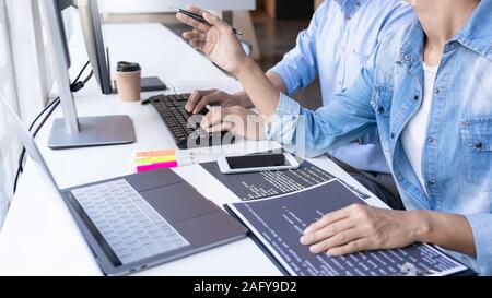 Young startup Programmers Sitting At Desks Working On Computers screen for Developing programming and coding to find solution to problem on New Applic Stock Photo