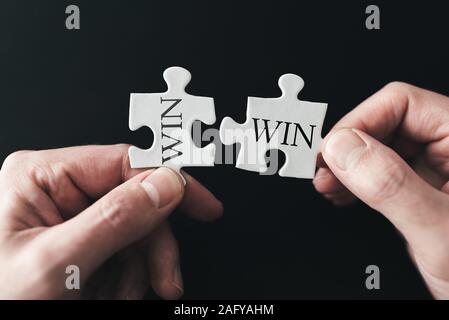 win win situation concept with hands holding puzzle pieces Stock Photo