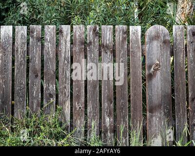 Old low and painted fence on cloudy day front view Stock Photo