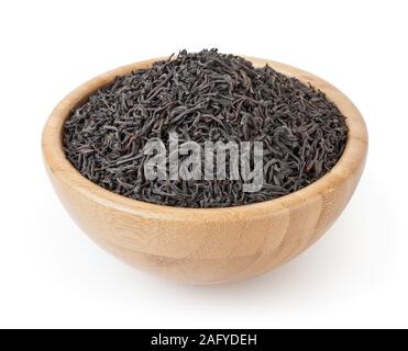 Dried black tea in wooden bowl isolated on white background with clipping path Stock Photo