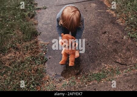stuffed animal jumps in puddle Stock Photo