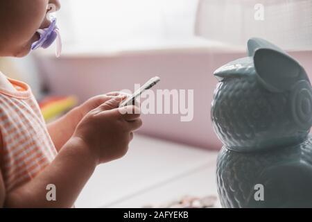 two year old putting money in her piggy bank Stock Photo