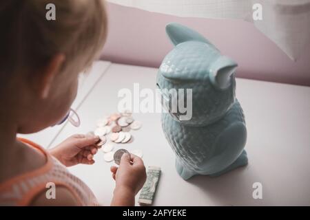 toddler girl saves up her coins Stock Photo